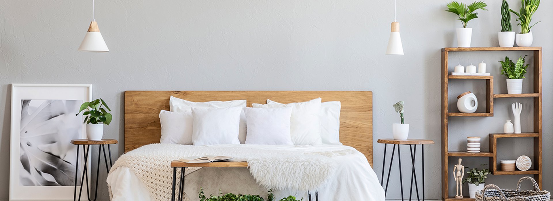 Patterned-pouf-and-basket-in-bright-bedroom-interior-with-lamps,-plants-and-poster-next-to-bed